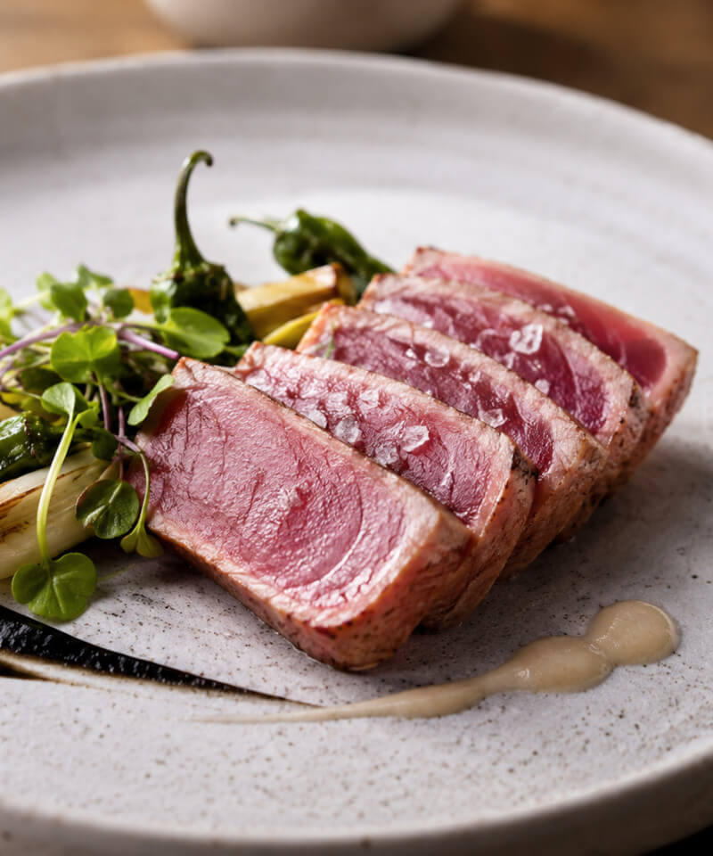 Plate of bluefin tuna slices with vegetables