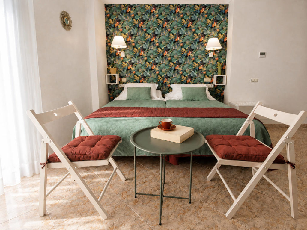 Habitación de hotel con una cama doble y dos sillas con mesita